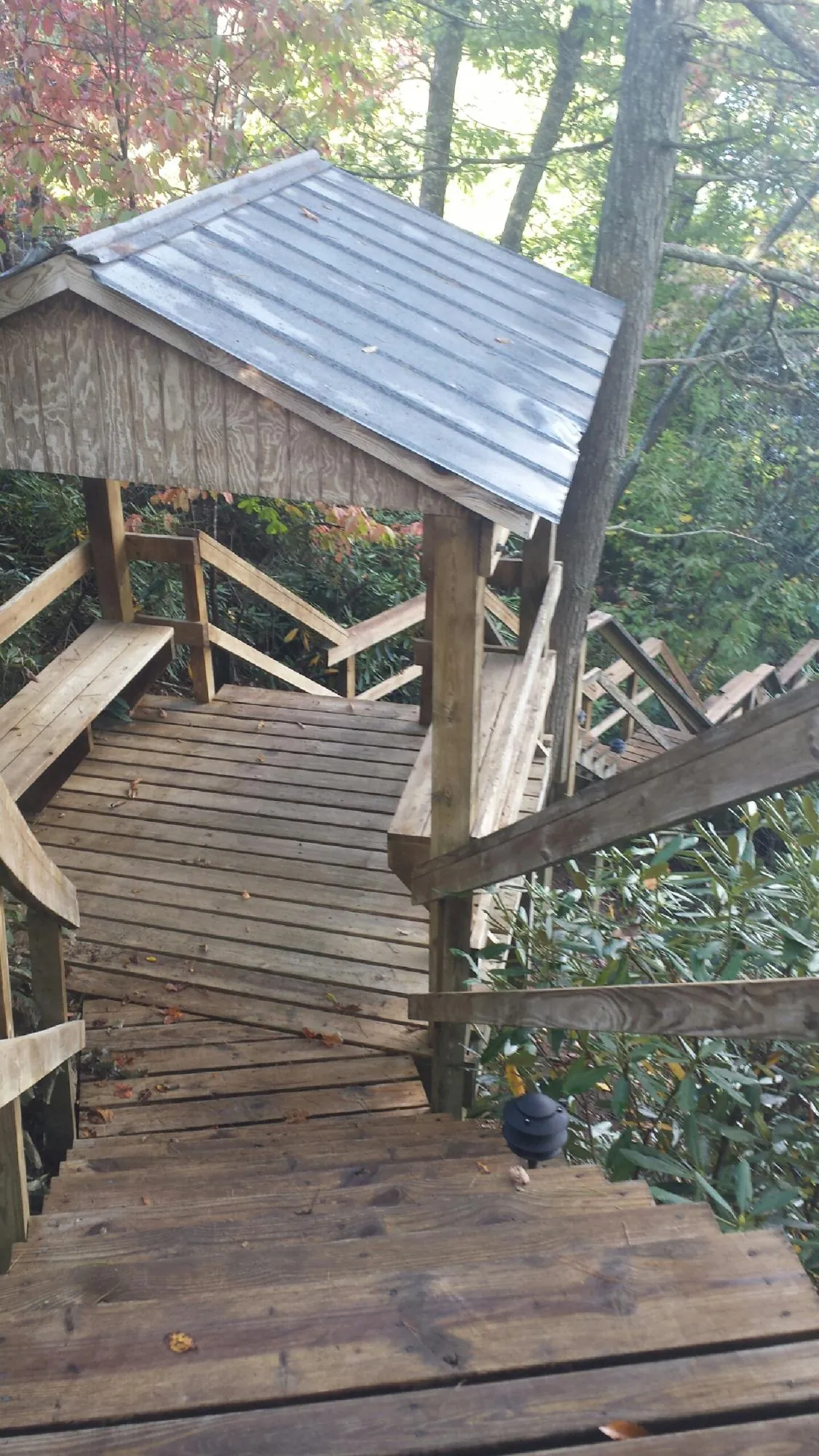 Metal roofed shelter over wooden steps on a wooded walkway — Skylight Repair & Installation work by our crew in Allenton